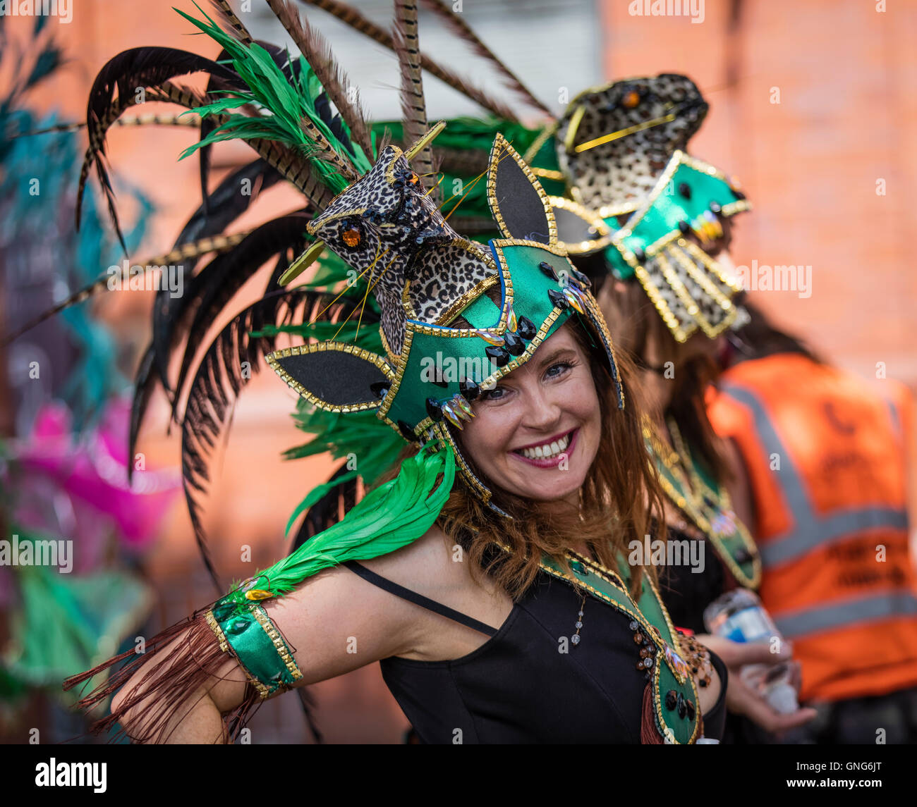 Belle jeune femme blanche qui prennent part à la parade de carnaval de Notting Hill et portant une coiffe verte Banque D'Images
