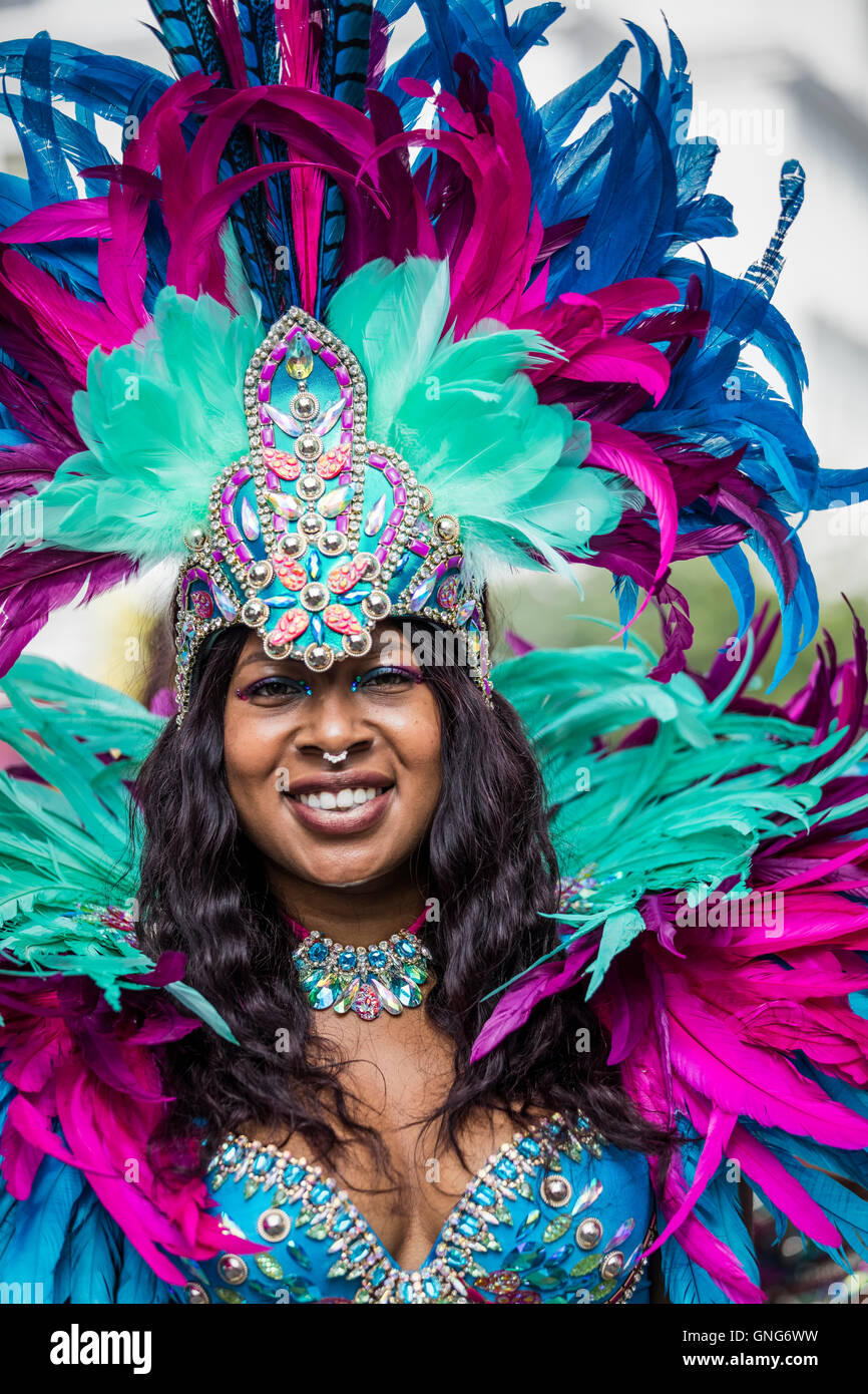 Belle jeune femme portant des Antilles avec costume de couleur vive rouge vert et bleu plumes au Notting Hill Carnival Banque D'Images