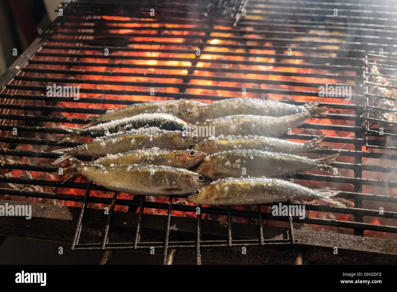 Sardines fraîches d'être grillé sur un feu de charbon dans la rue à Cascais, Portugal Banque D'Images