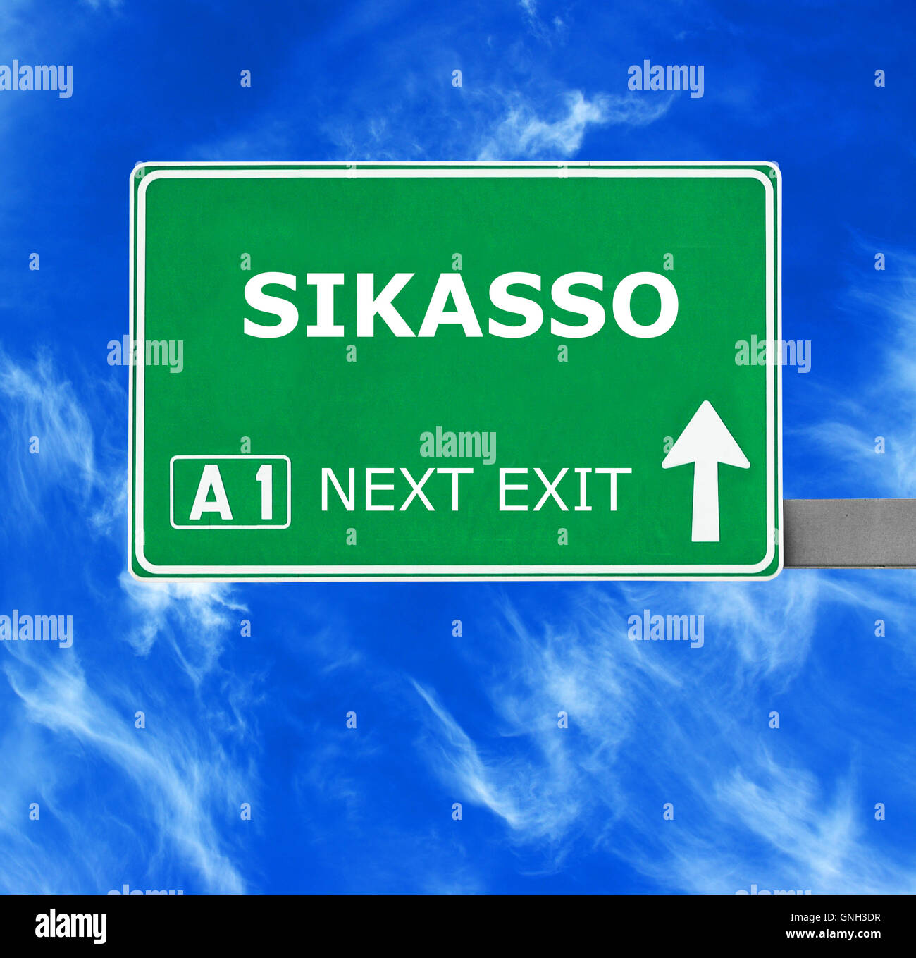 Panneau routier de Sikasso contre ciel bleu clair Banque D'Images
