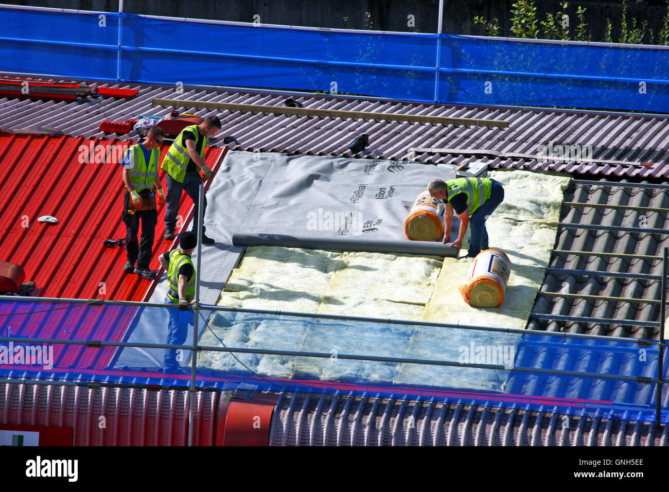 Bâches d'isolation et d'ouvriers un toit rouge à Paisley en Écosse Banque D'Images