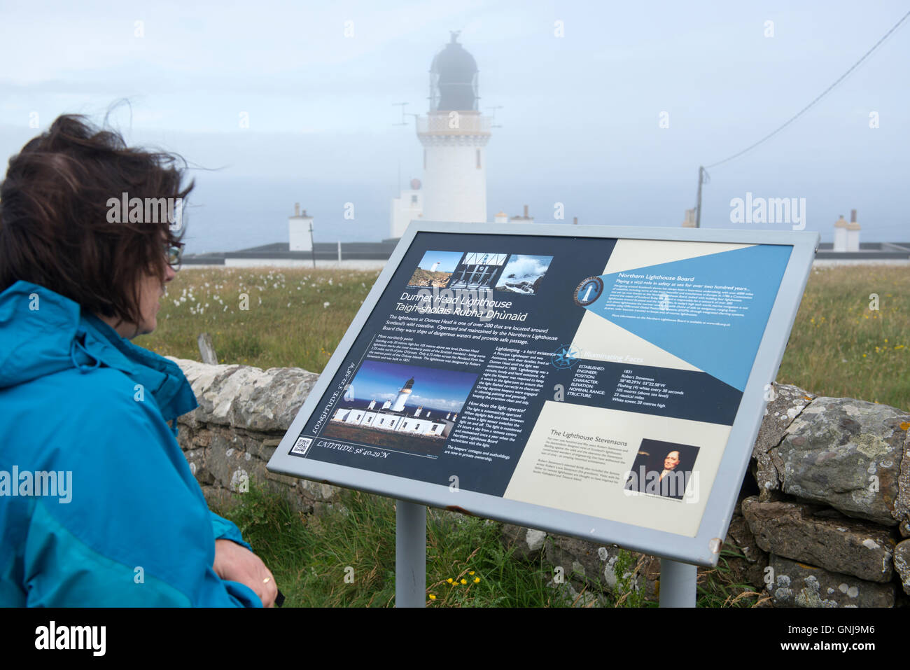 Les touristes à la recherche à un panneau d'information à Dunnett Head en Ecosse, le point le plus au nord sur la Grande-Bretagne Banque D'Images