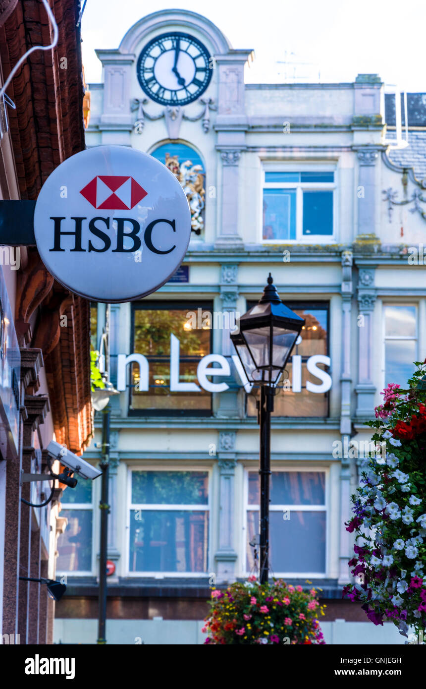 Un signe de la HSBC est suspendu au côté d'une banque à Reading, Berkshire et John Lewis peut être vu dans la distance. Banque D'Images