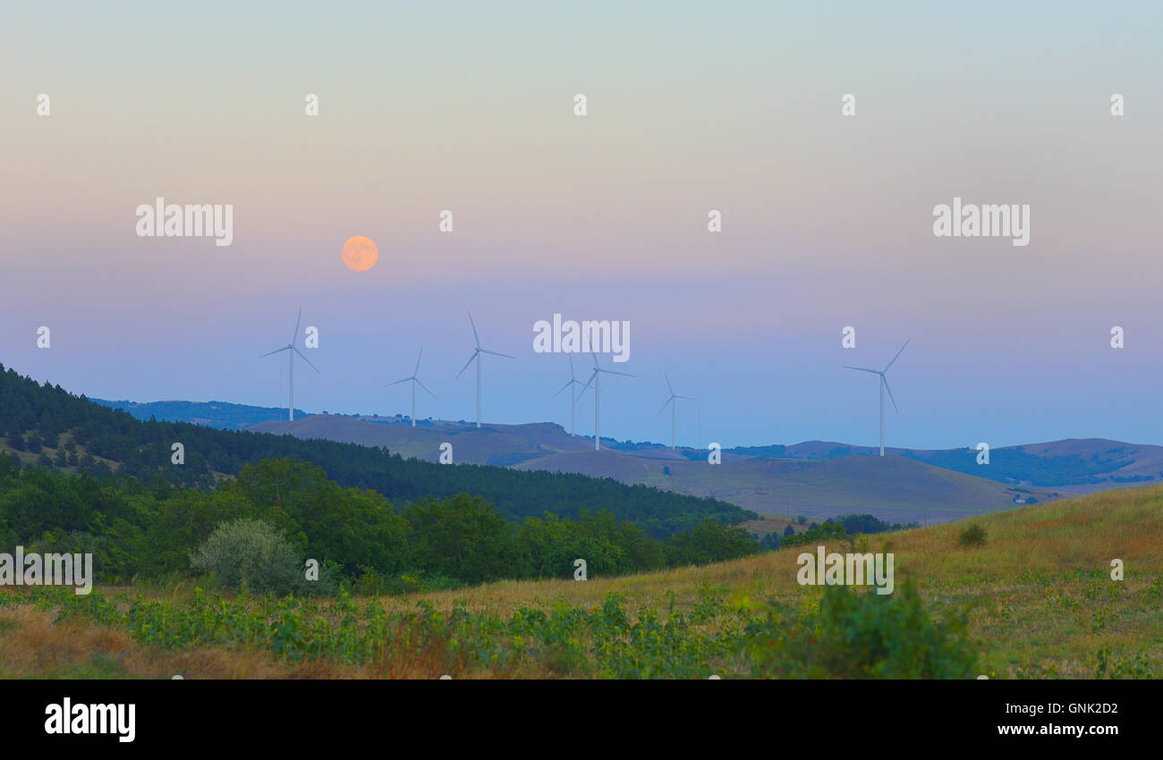 La station de vent Éoliennes et la pleine lune au ciel Banque D'Images
