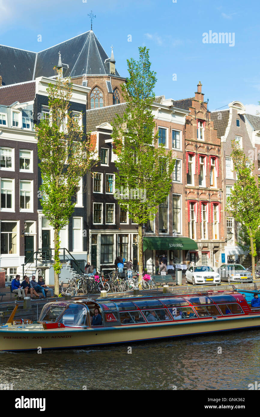 Les touristes de croisière bateau canal pass voyage restaurants, bars et maisons sur rue à canal Herengracht, Amsterdam, Holla, Banque D'Images