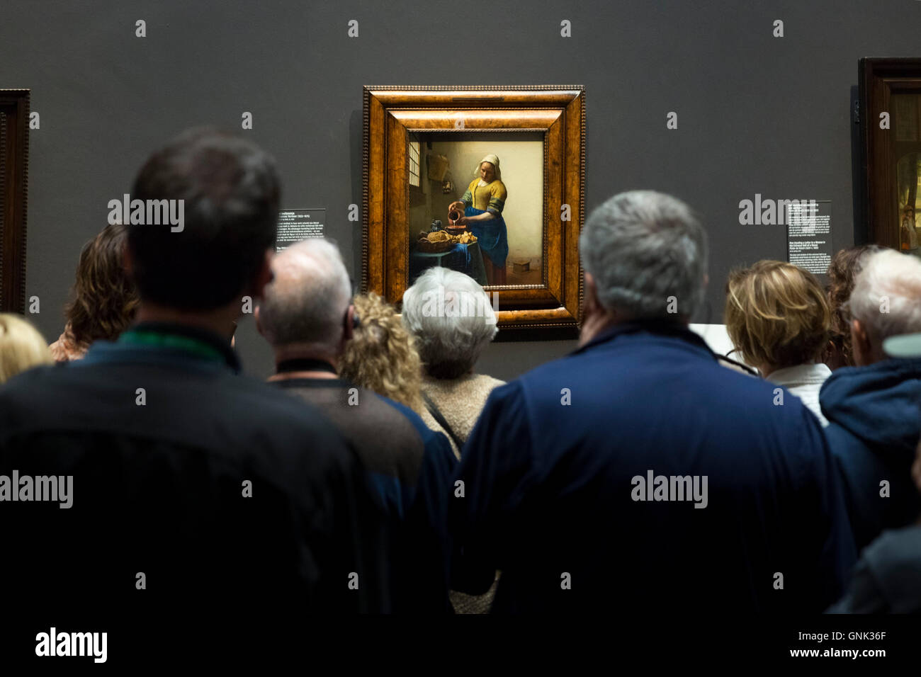 Les visiteurs l'affichage tableau de Johannes Vermeer La Laitière' à 'Rijksmuseum, Amsterdam, Pays-Bas Banque D'Images