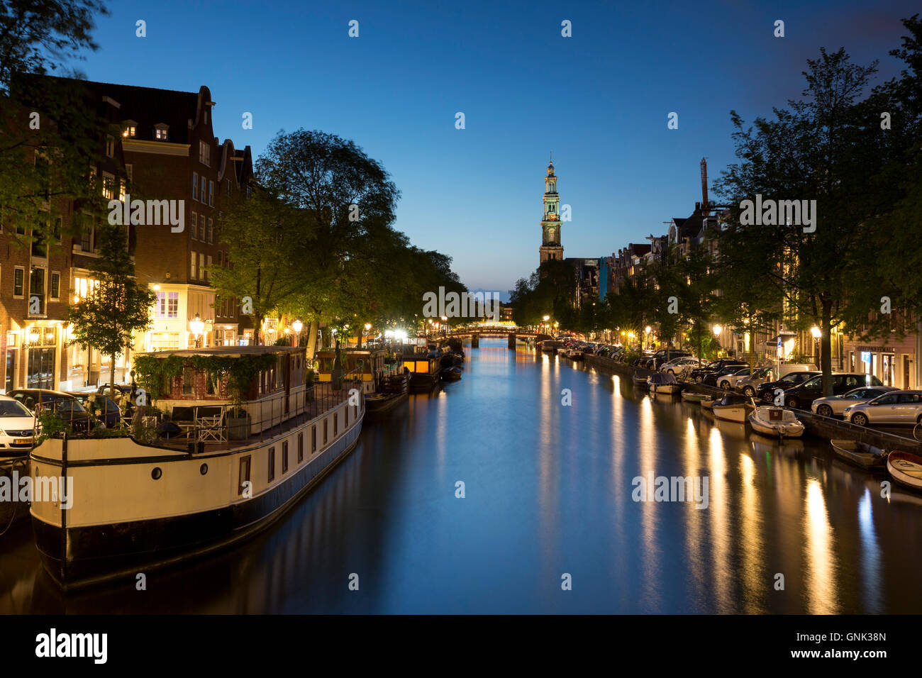Scène du canal typique d'Amsterdam - l'église Westerkerk, canal et péniches le long de Prinsengracht à Amsterdam, Hollande Banque D'Images