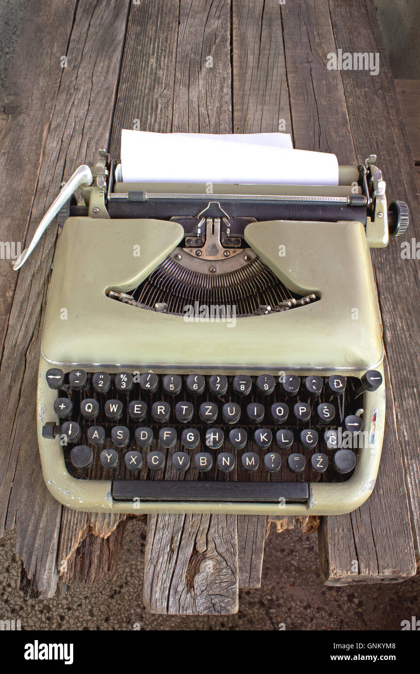 Vieille machine à écrire avec le papier blanc sur fond de bois Banque D'Images