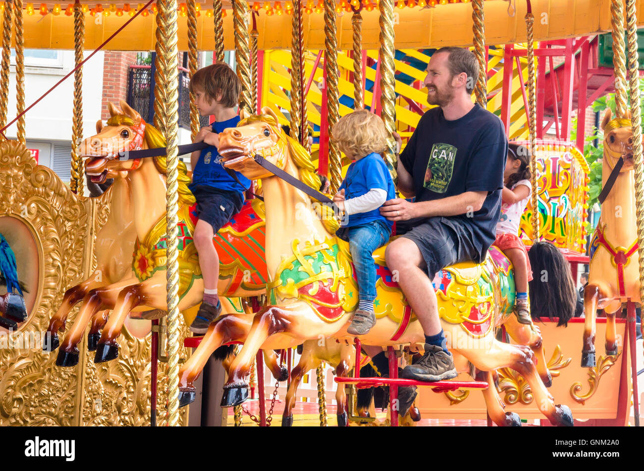 Un père et fils monter sur un manège à GUNWHARF QUAYS de Portsmouth, Royaume-Uni. Banque D'Images