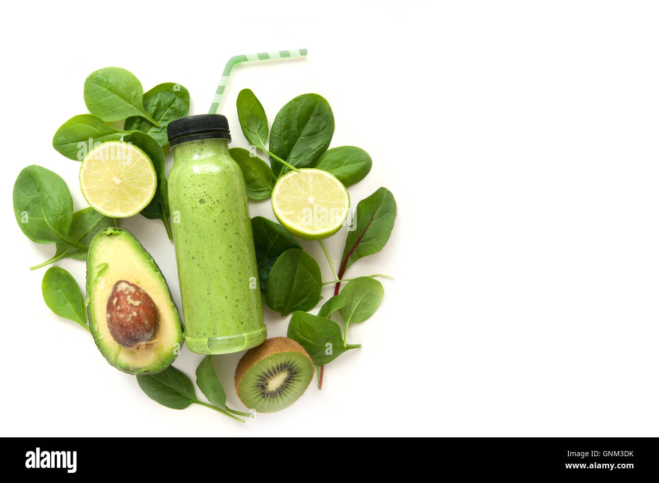 Smoothie aux fruits et légumes verts dans une bouteille entourée par des ingrédients Banque D'Images
