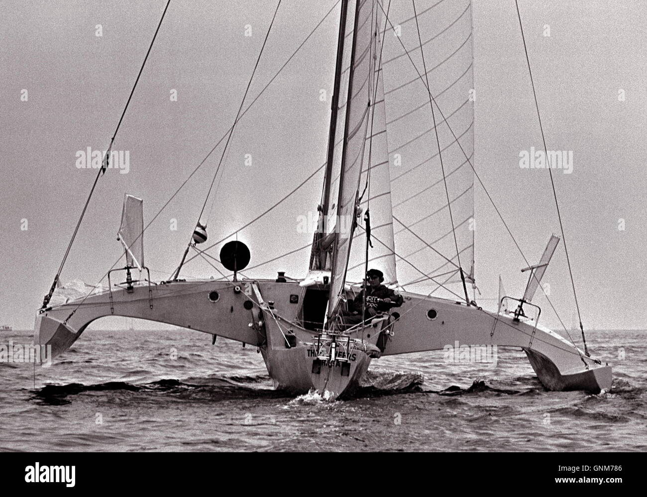 Nouvelles photos d'AJAX. 1976. PLYMOUTH, en Angleterre. - RACE - OSTAR MANQUANT - MIKE MCMULLEN DANS LE TRIMARAN THREE CHEERS AU DÉBUT DE LA COURSE AU LARGE DE PLYMOUTH. Il n'a jamais vu de nouveau. PHOTO:JONATHAN EASTLAND/AJAX REF:2760506 26 Banque D'Images