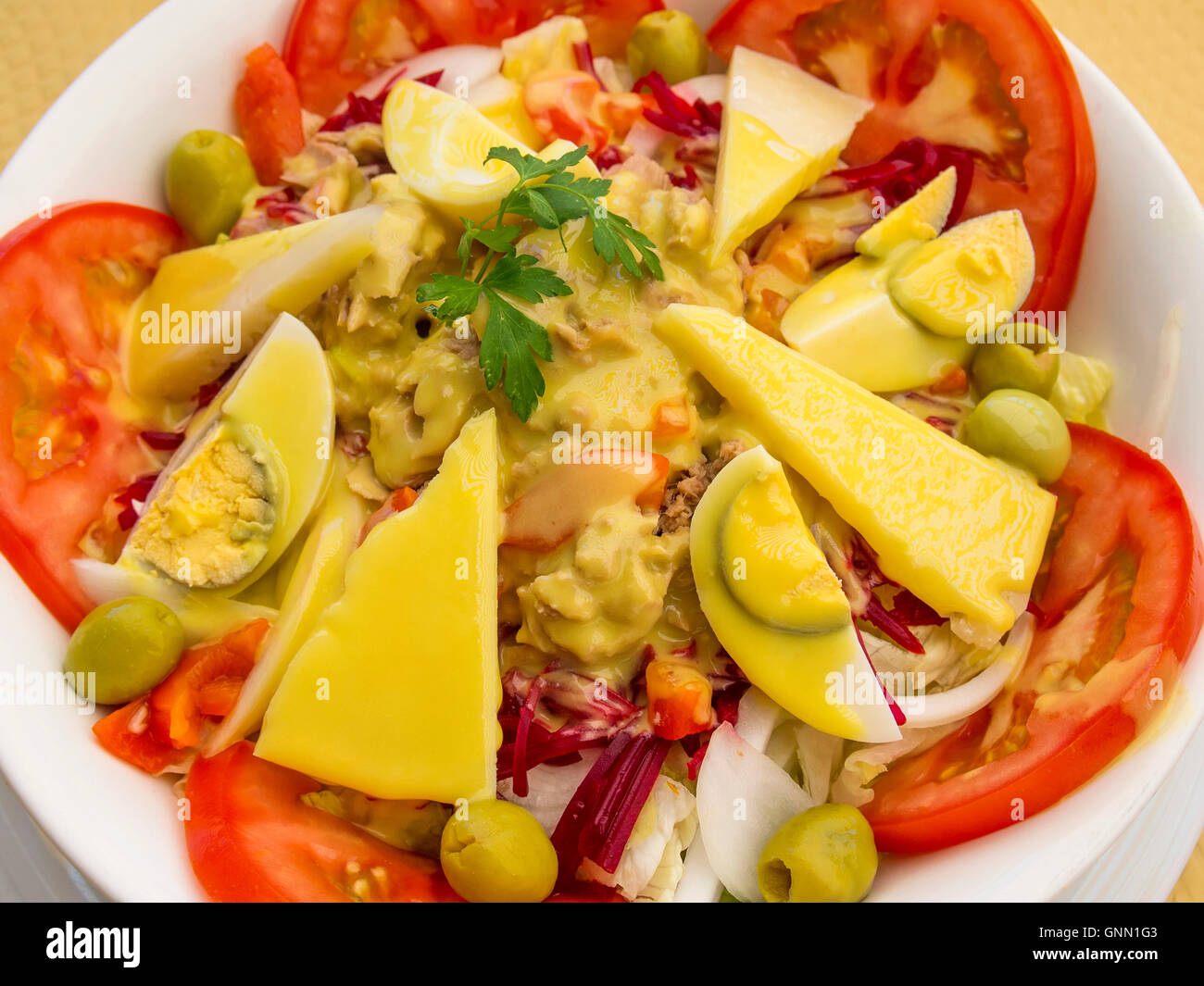 Avec salade de tomates, fromage, olives, oeufs, thon, les betteraves, les oignons et la sauce à la moutarde Banque D'Images