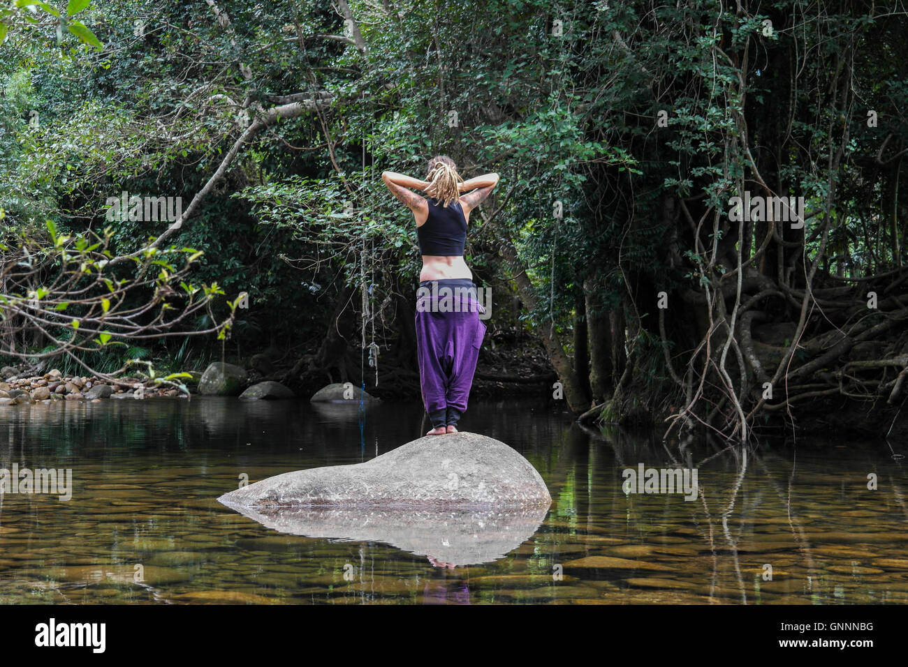 Jeune femme méditer près d'une rivière dans le Queensland - Australie Banque D'Images
