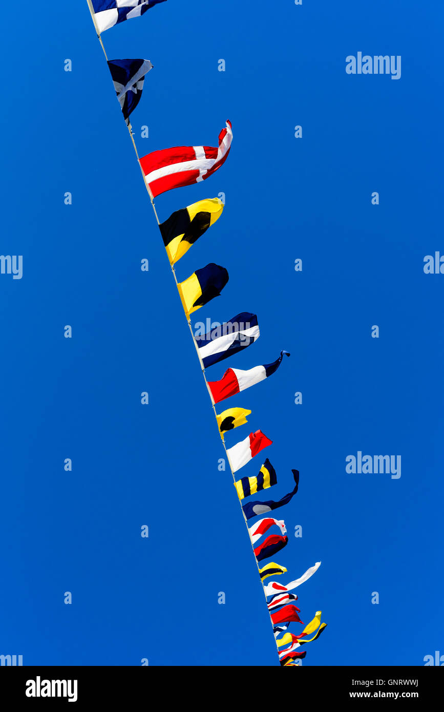 Bunting flags par le vent sur une ligne contre le ciel bleu. Banque D'Images