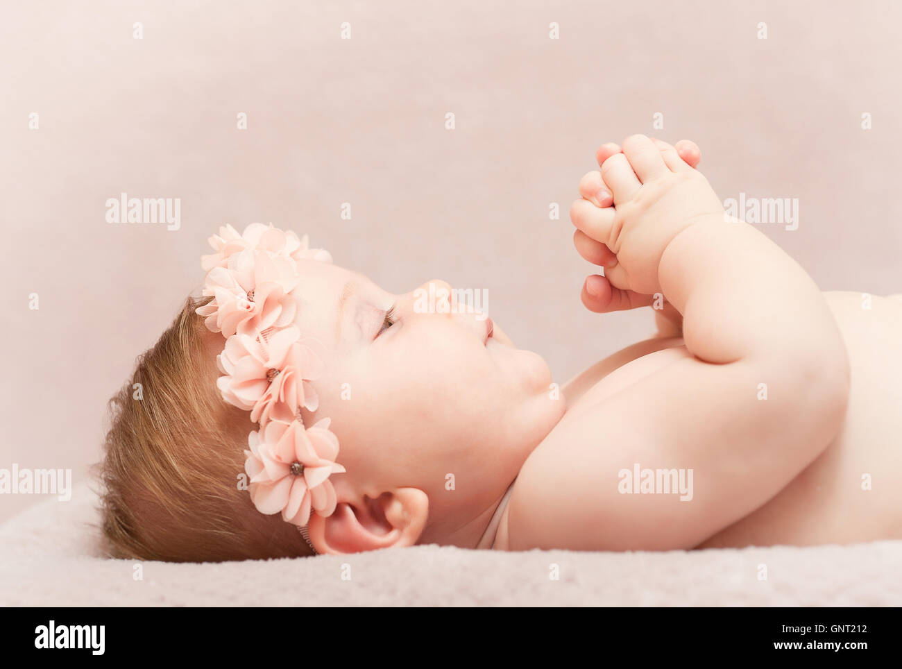 Portrait of caucasian newborn avec serre-tête fleur rose Banque D'Images