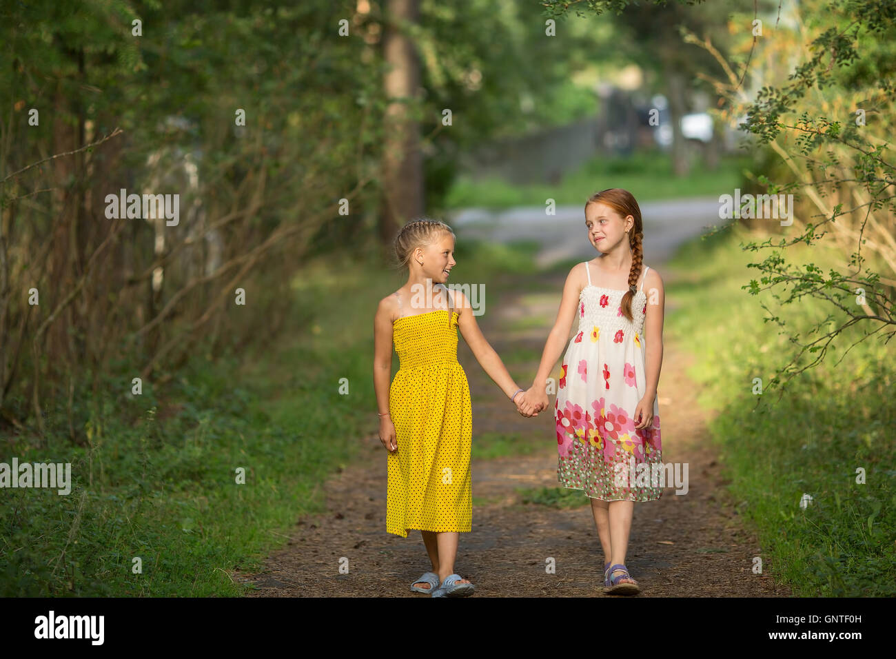 Deux petites filles par la poignée, promenade dans le parc. Banque D'Images