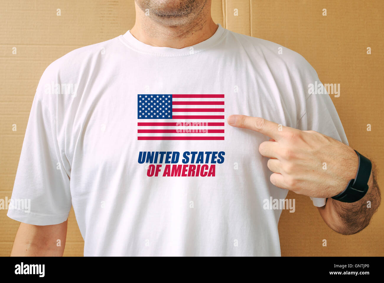 Bel homme portant fièrement des t-shirt avec drapeau USA imprimé sur la poitrine, concept de patriotisme, de fierté et d'amour pour un Banque D'Images