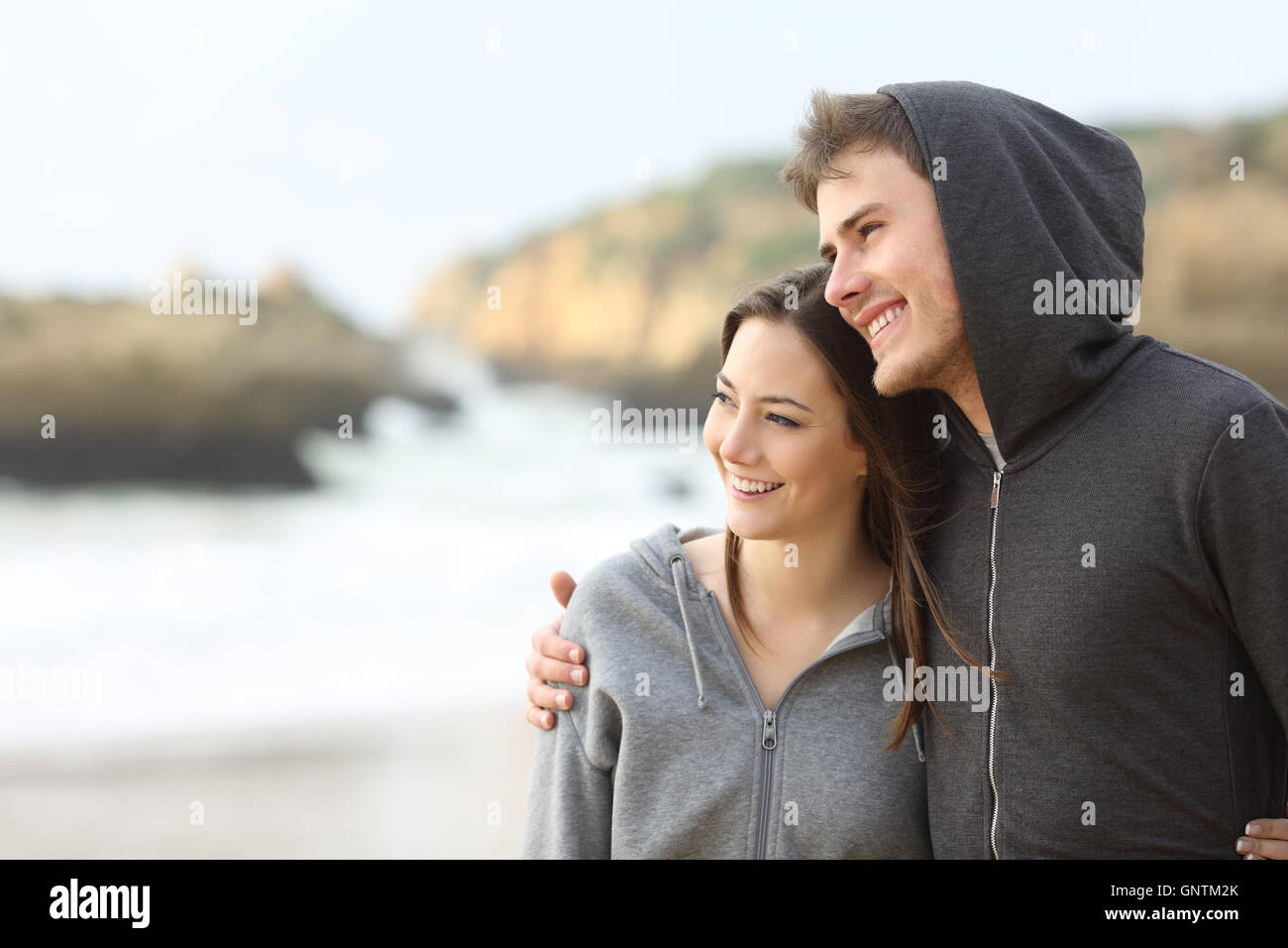 Heureux couple d'ados accolades et de prendre une marche sur la plage Banque D'Images