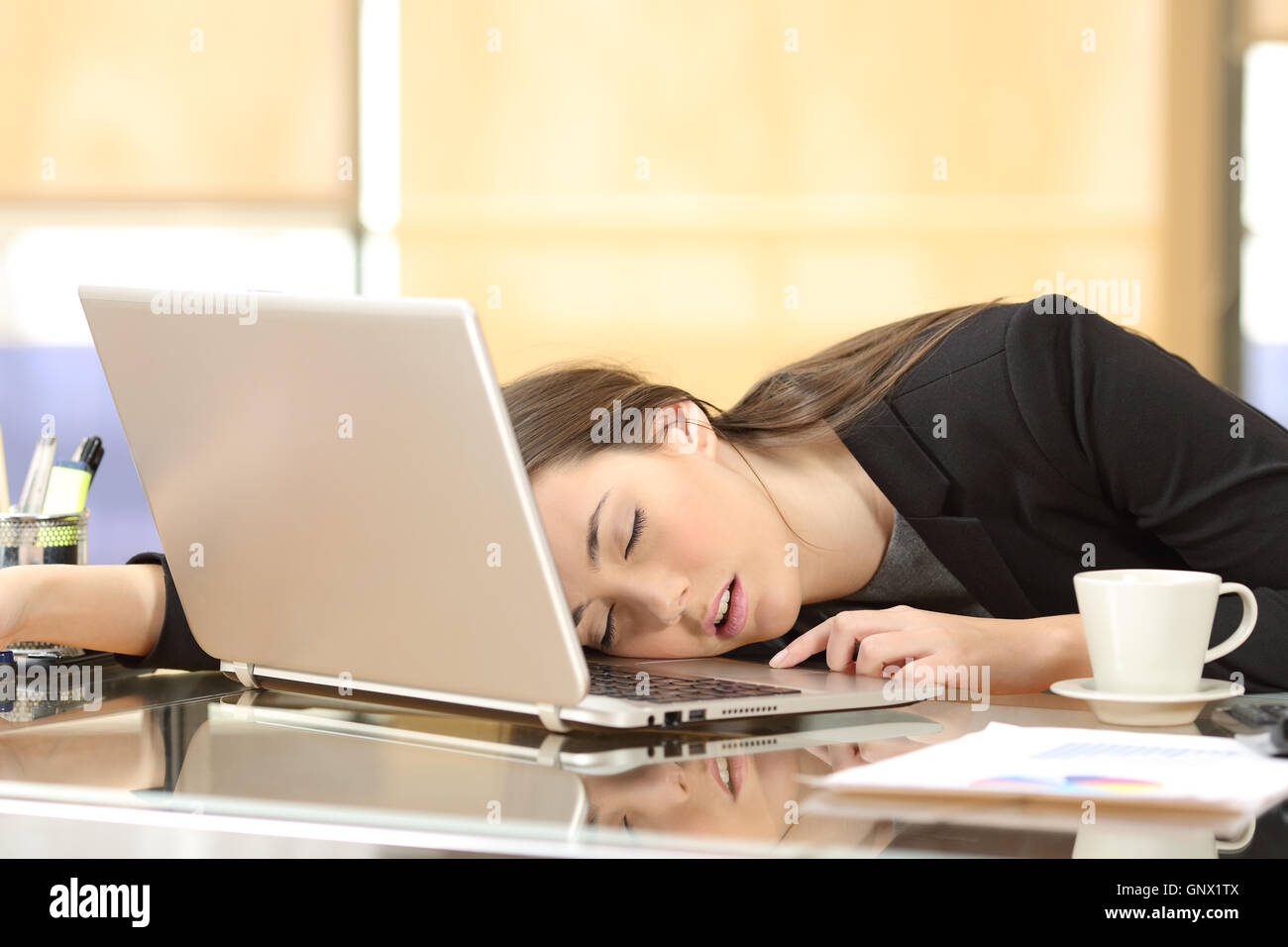 Surmené et fatigué businesswoman sleeping sur une portable, dans un bureau au travail dans son bureau Banque D'Images