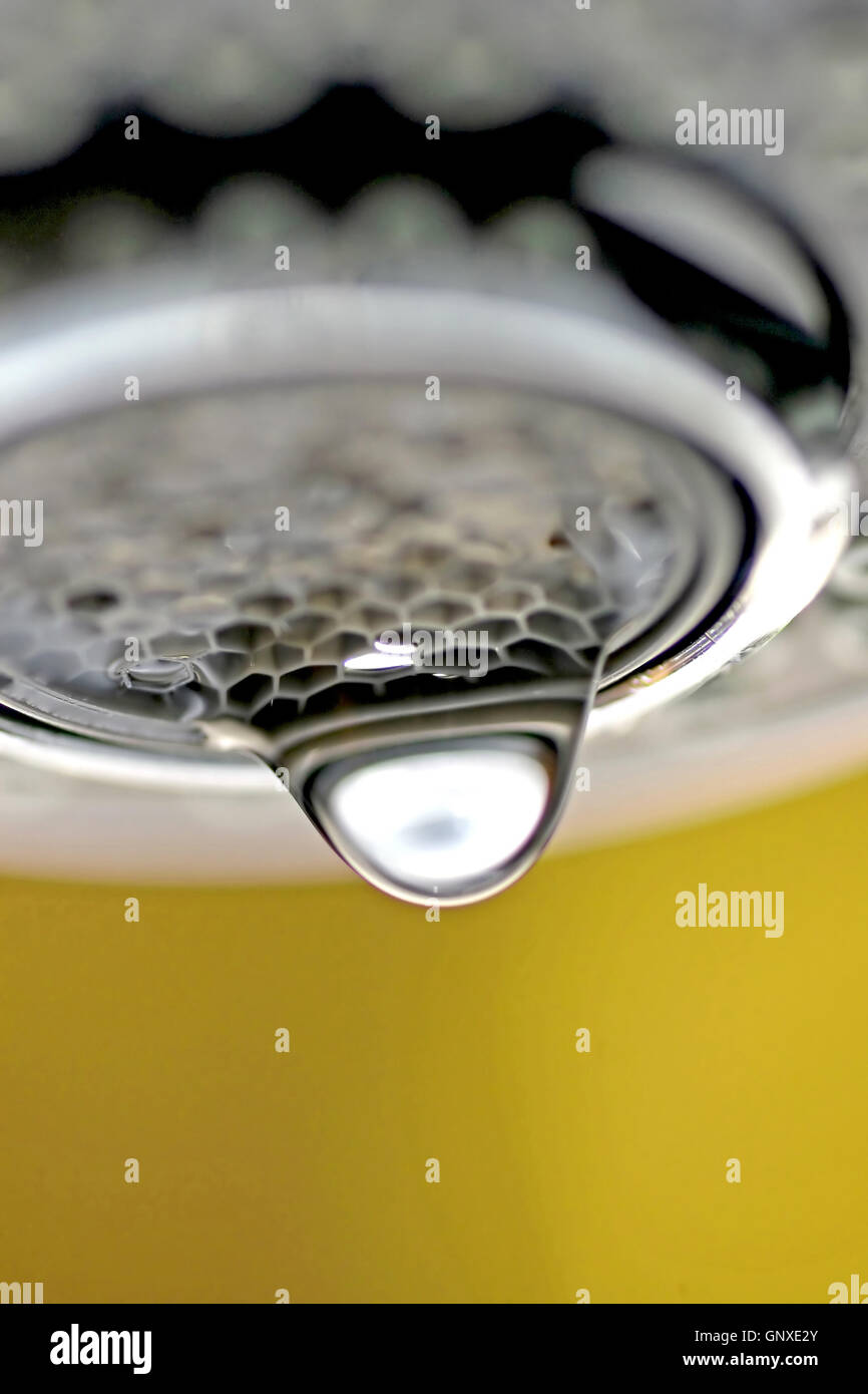 Une macro d'un robinet robinet blanc / dégoulinant de fond jaune. Banque D'Images