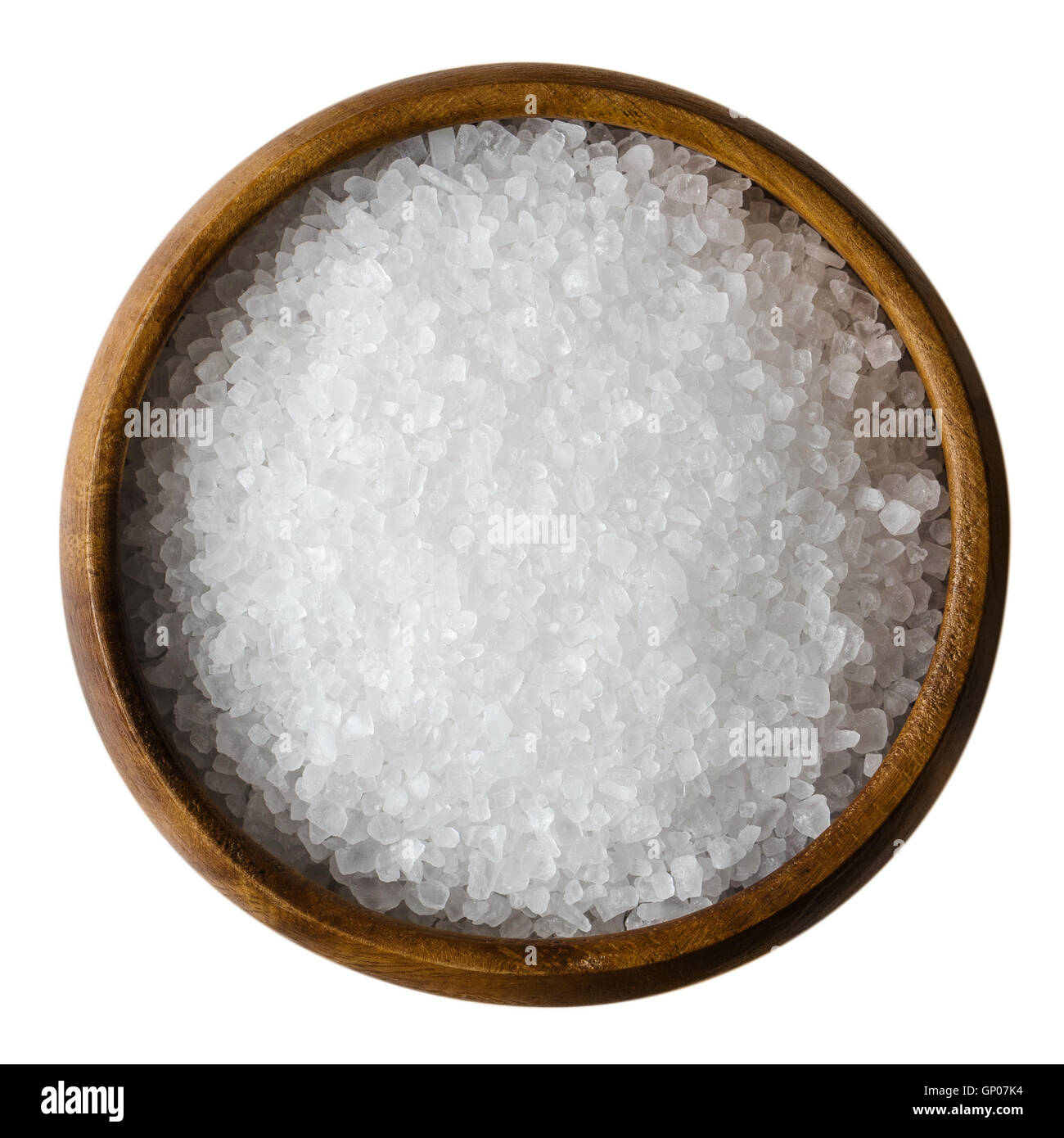 Le sel de mer dans un bol en bois sur fond blanc. Également appelé bay sel ou sel solaire, est utilisé en cuisine et cosmétiques. Banque D'Images
