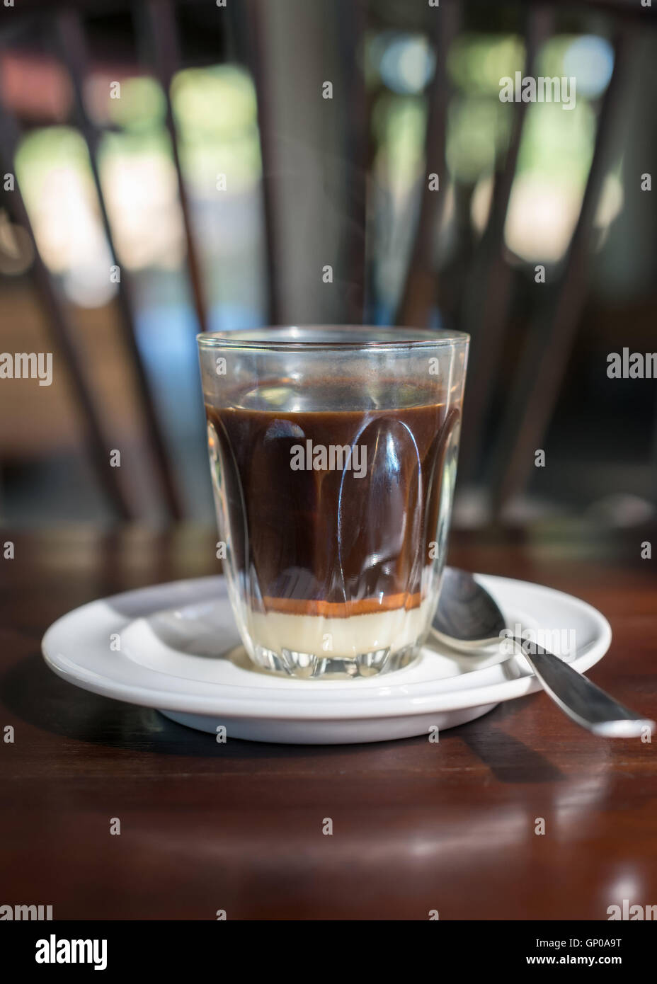 Tradition thaïlandaise café chaud avec le lait condensé sucré dans old style cup, servi sur table en bois. Banque D'Images