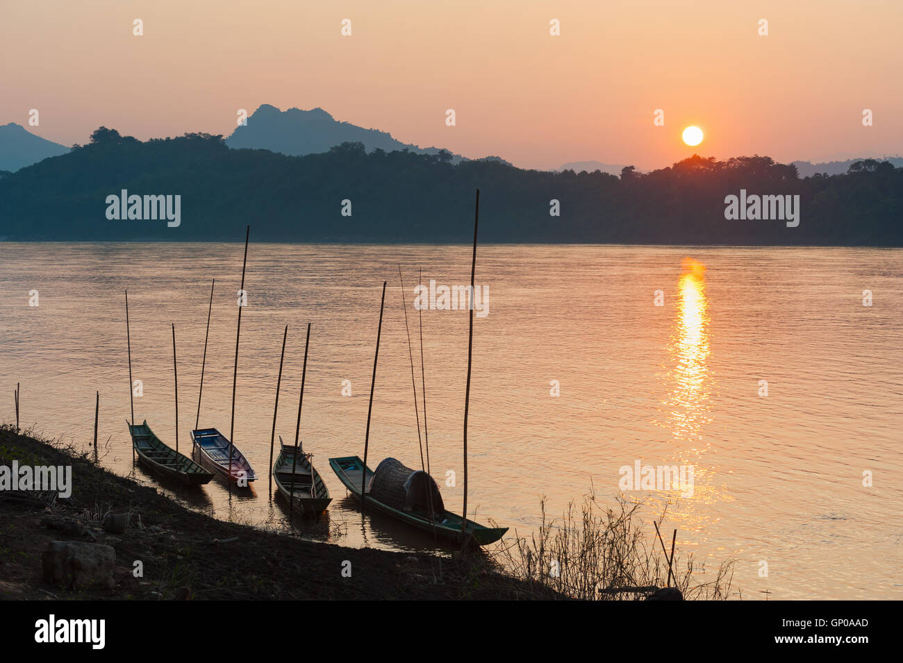 Bateaux sur le fleuve dans le lever du soleil ou le coucher du soleil à Luang Prabang, Laos. Banque D'Images