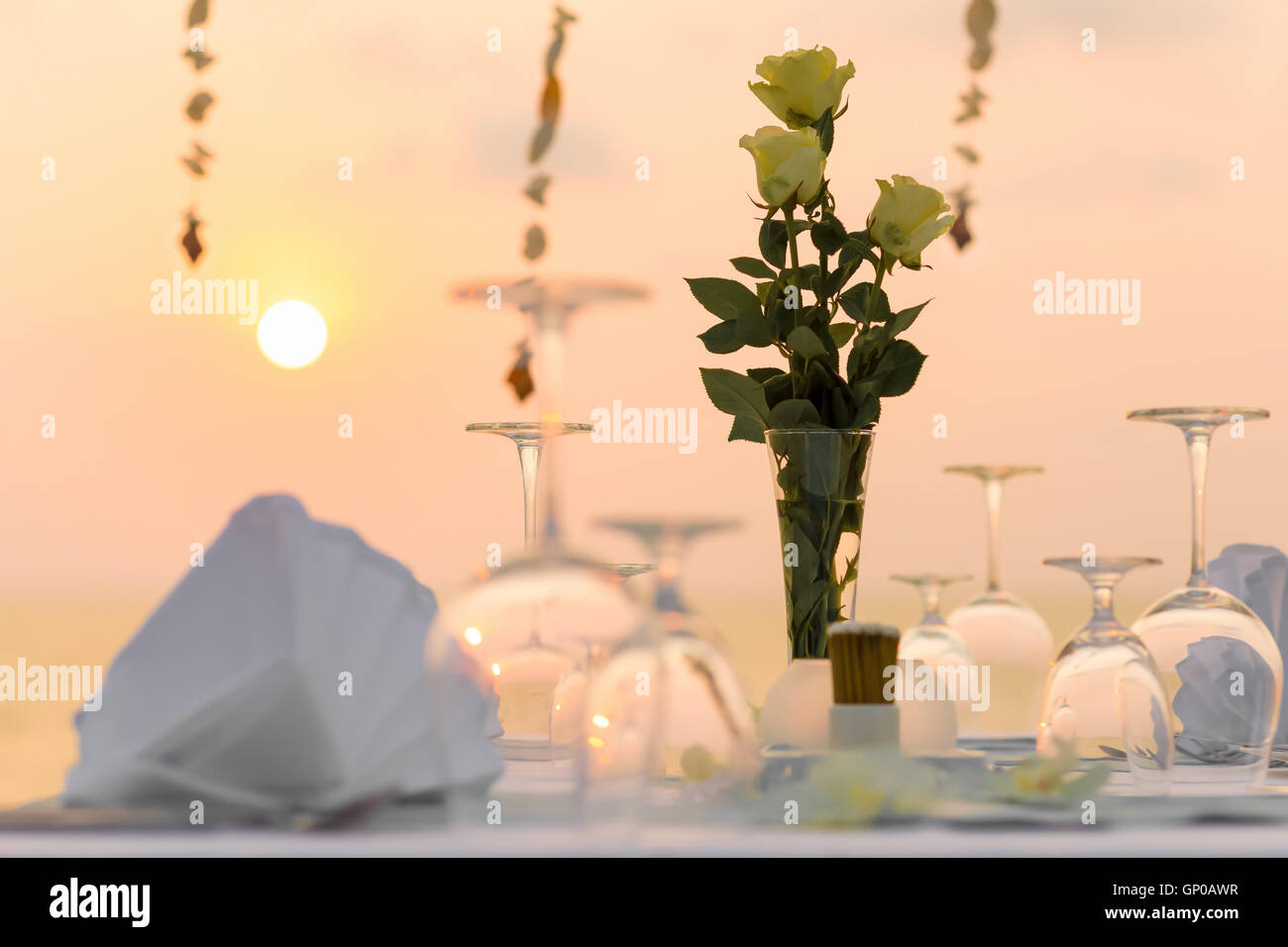 Dîner romantique sur la plage au coucher du soleil. Banque D'Images