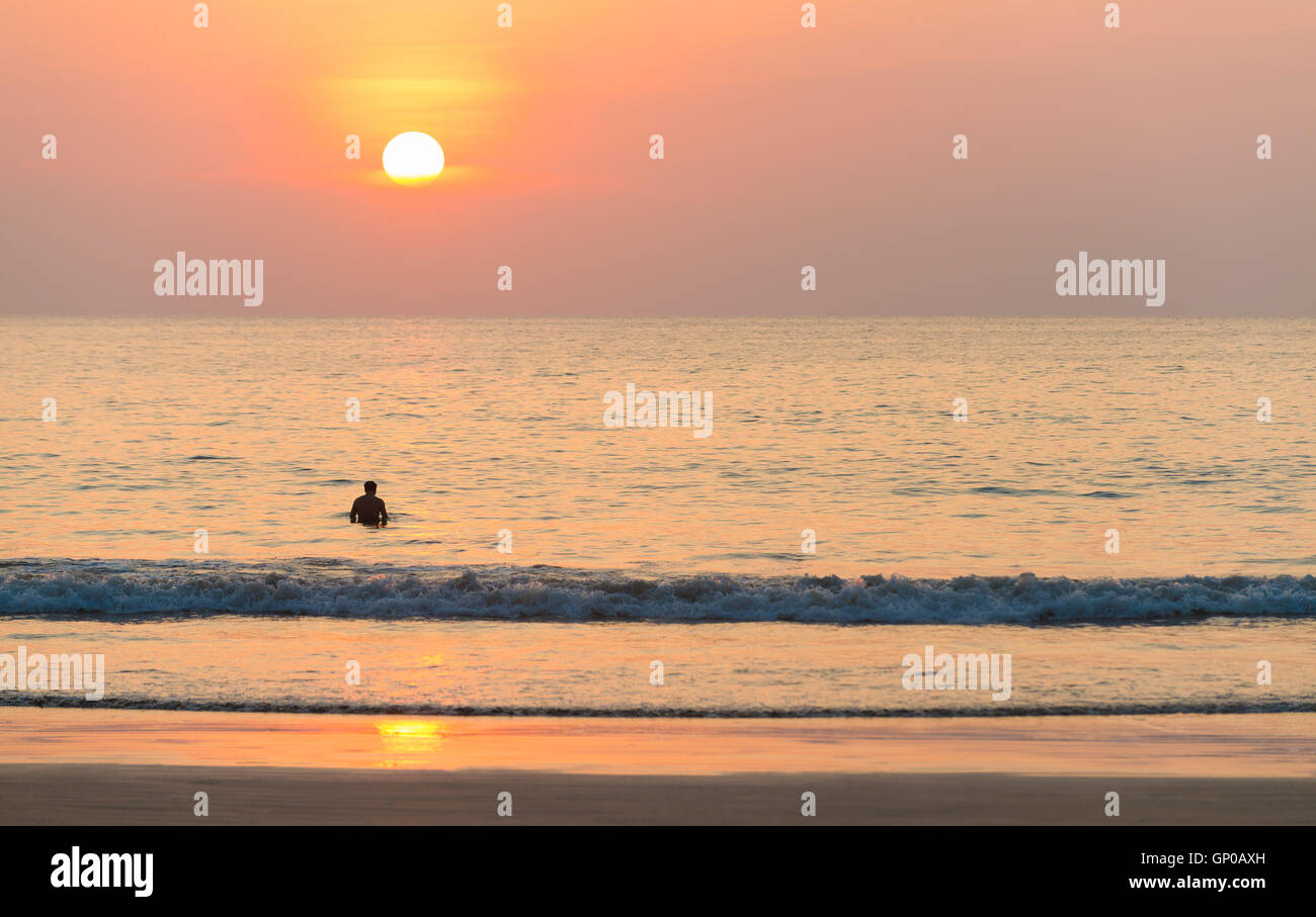 Seascape, silhouette homme seul au coucher du soleil. Banque D'Images