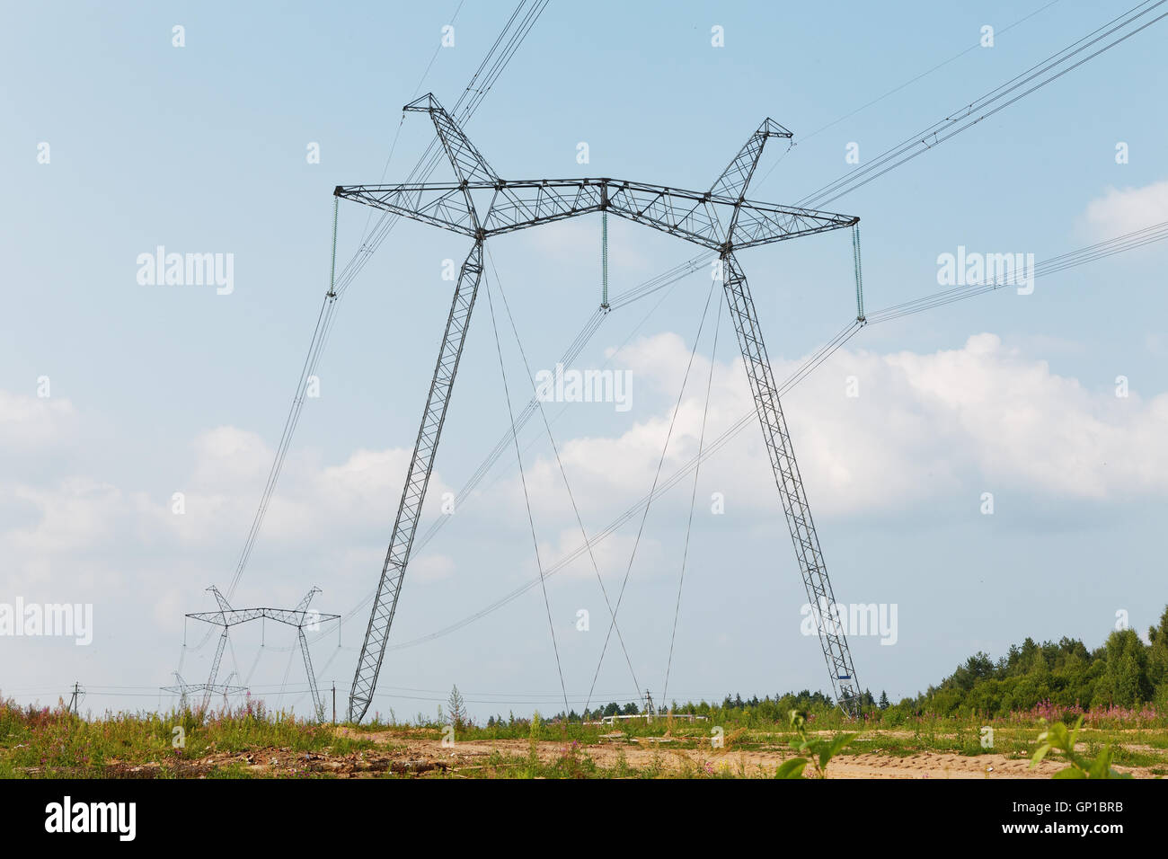 Lignes de transmission à haute tension contre le ciel avec des nuages Banque D'Images