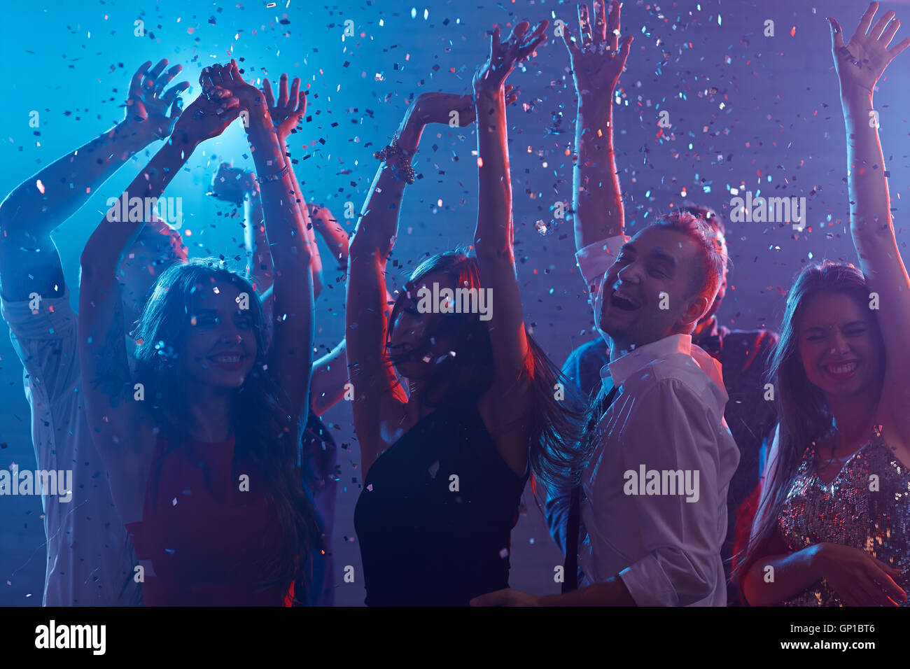 Les jeunes gens joyeux avec mains bénéficiant en soirée dance club Banque D'Images