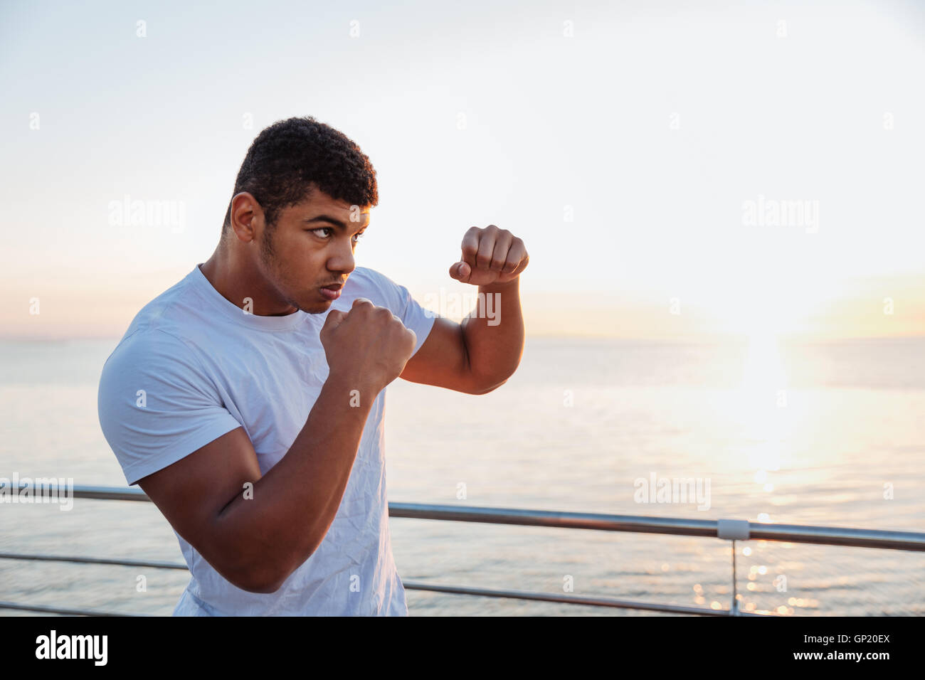 Concentrés african american man shadow boxing boxeur pratiquant à l'extérieur dans la matinée Banque D'Images