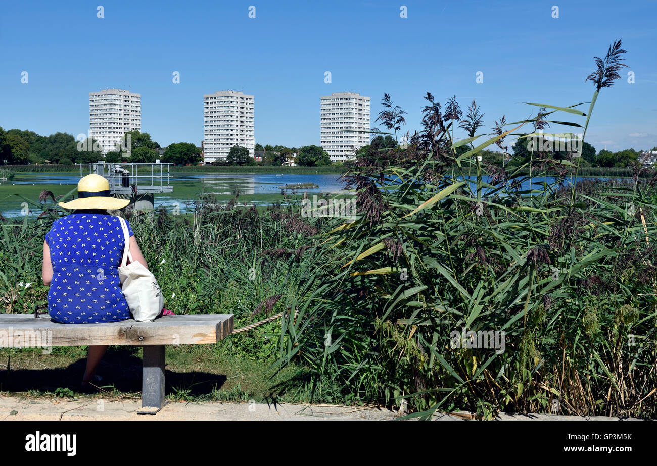 Lady wearing straw hat assis sur un banc à Woodberry zones humides. La réserve est gérée par la London Wildlife Trust Banque D'Images