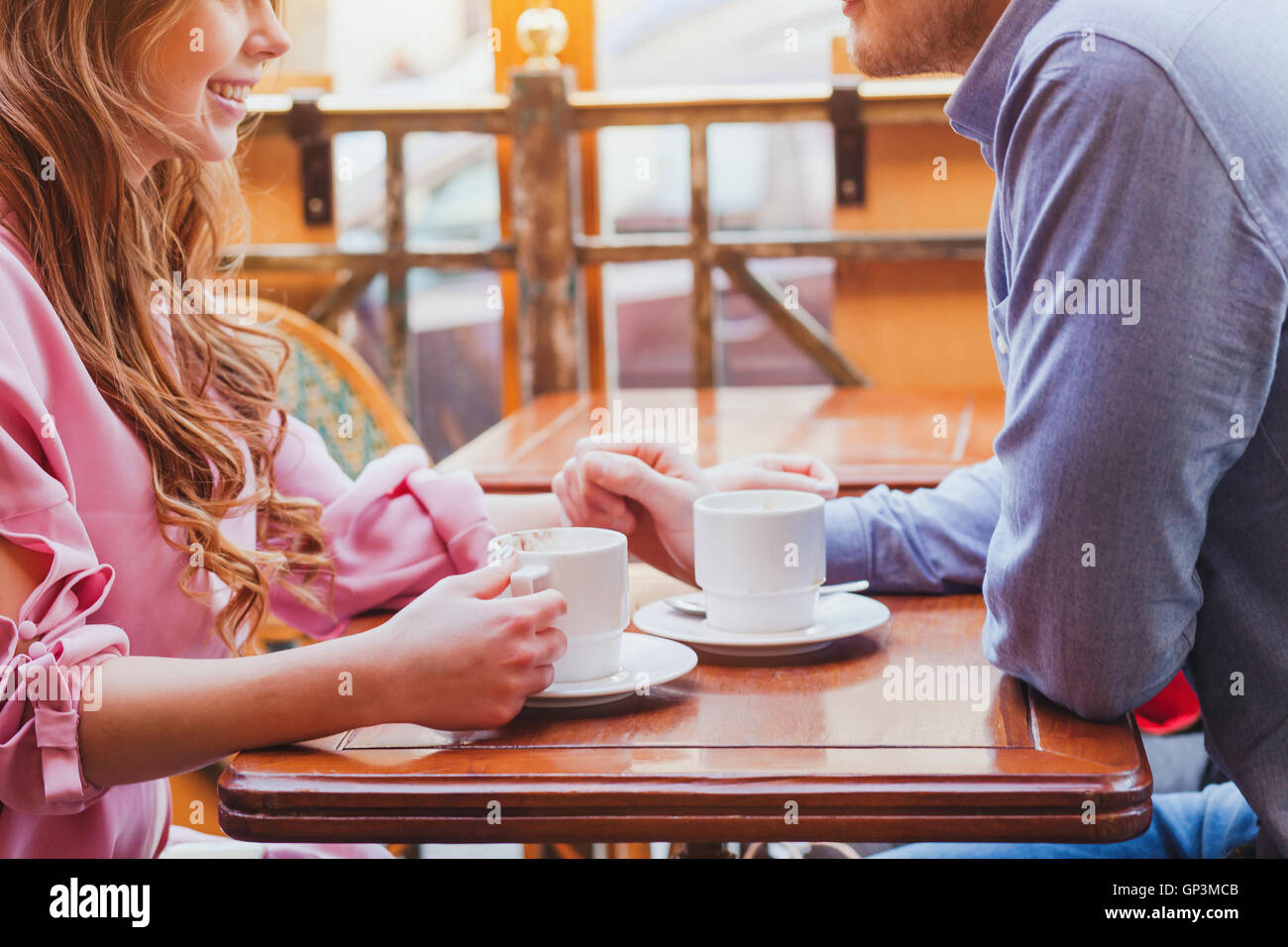 Dating, mains de couple dans un café confortable, boire du café Banque D'Images