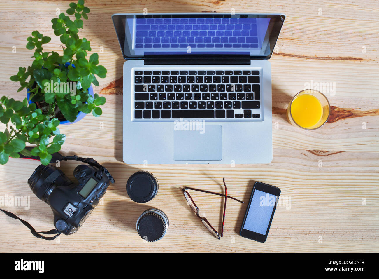 Travail photographe, engins, vue de dessus de bureau avec ordinateur portable, d'appareil, les objectifs et le smartphone Banque D'Images