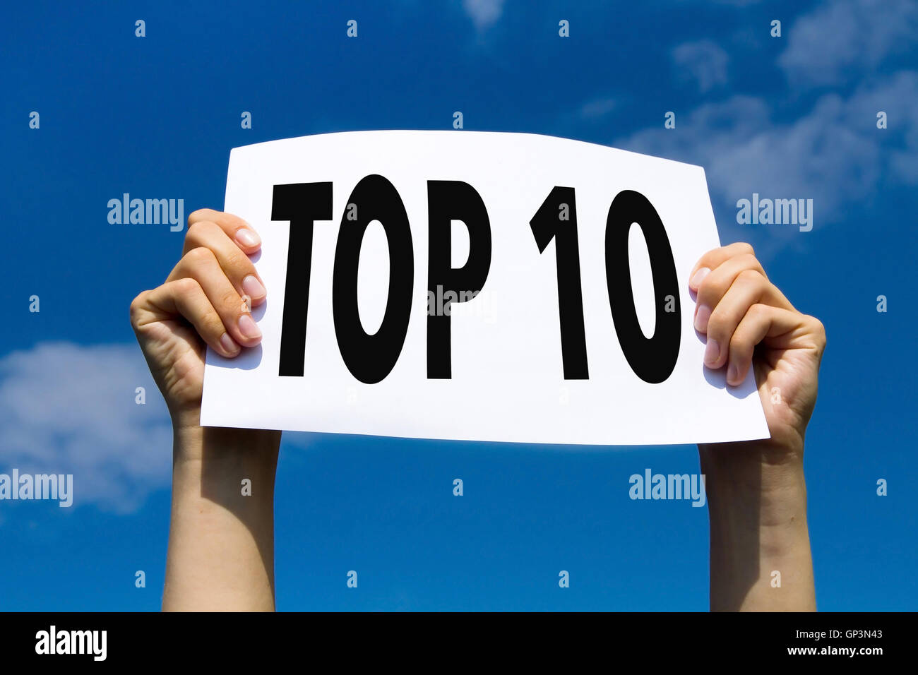 Top 10, mains holding sign in blue sky Banque D'Images