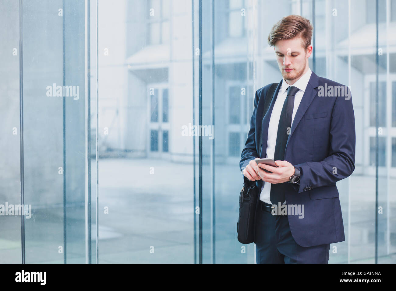 Businessman using smartphone près de l'immeuble de bureaux Banque D'Images
