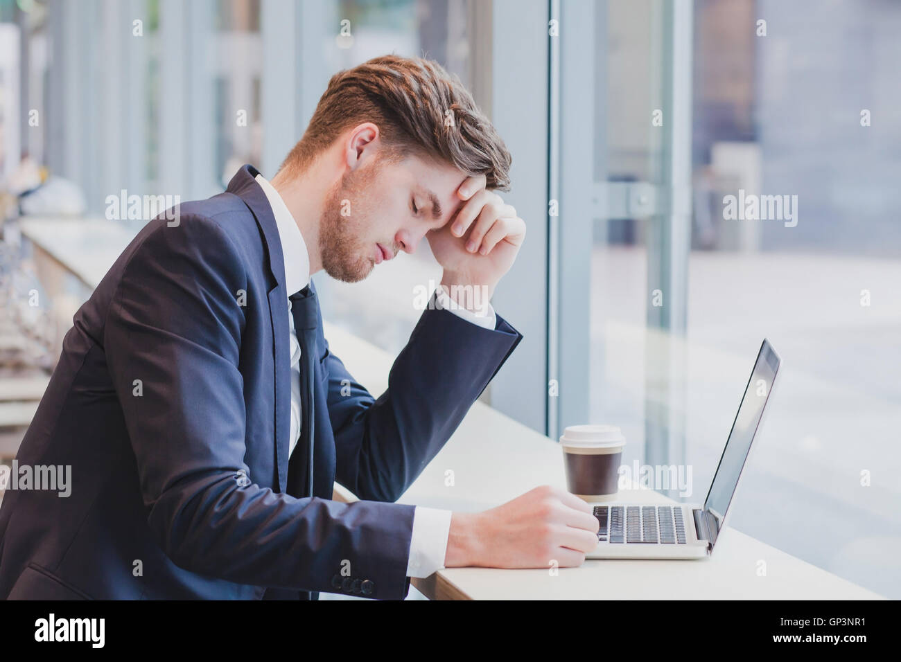 Maux de tête, fatigue l'homme d'affaires près de l'ordinateur portable Banque D'Images