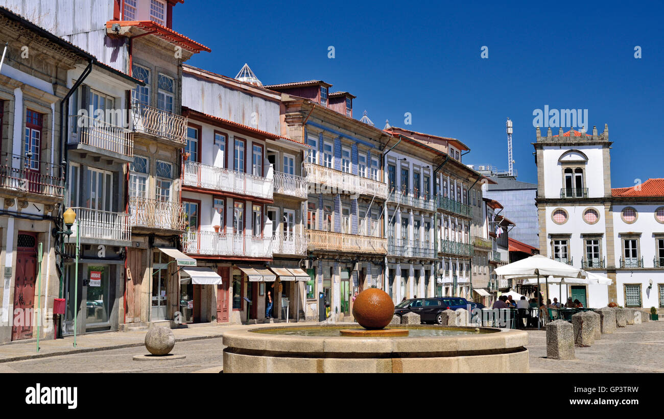 Portugal : le centre ville place avec fontaine et maisons de la cité médiévale dans le centre historique de Guimaraes Banque D'Images