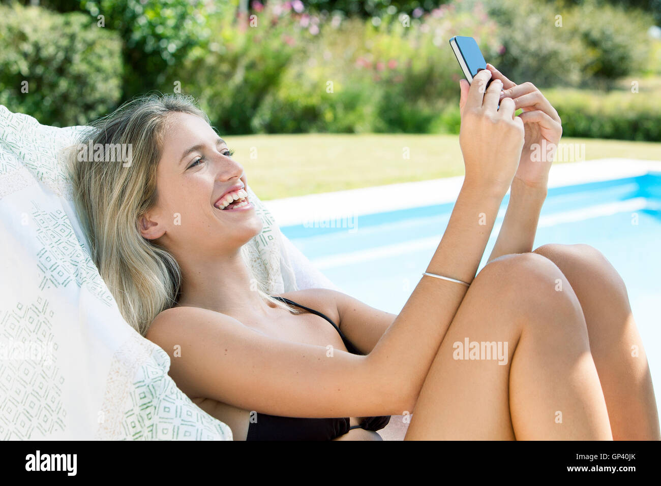 Woman relaxing by extérieure avec smartphone Banque D'Images