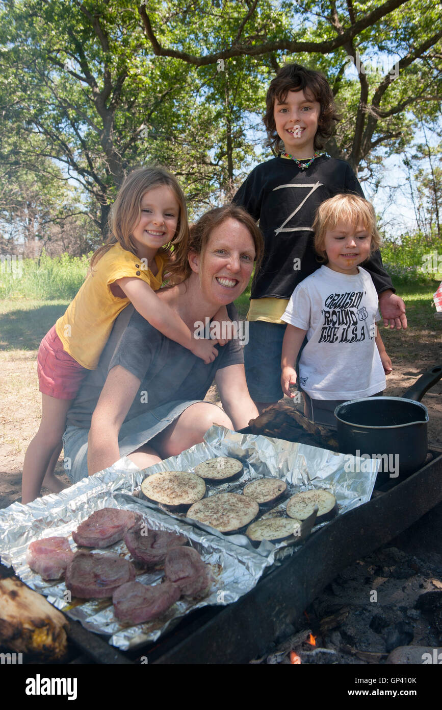 La mère et les enfants à l'ensemble de cuisson camping Banque D'Images