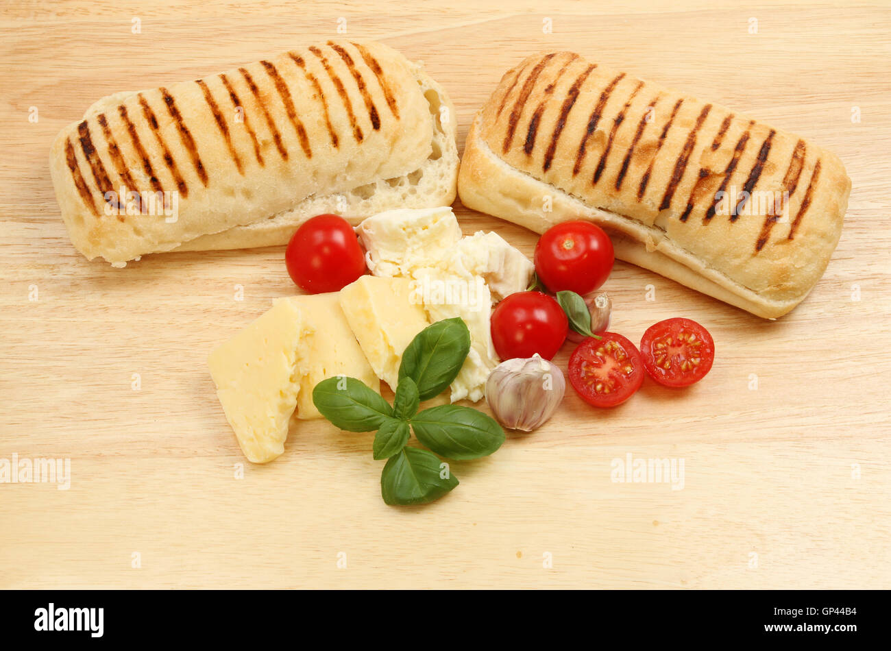 Rouleaux Pannini et remplissage ingrédients sur une planche à découper en bois Banque D'Images