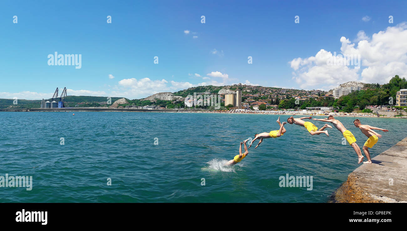 Garçon sautant dans l'eau de mer à Balchik, Bulgarie. Vacances d'arrière-plan. Joie, Bonheur et loisirs concept Banque D'Images