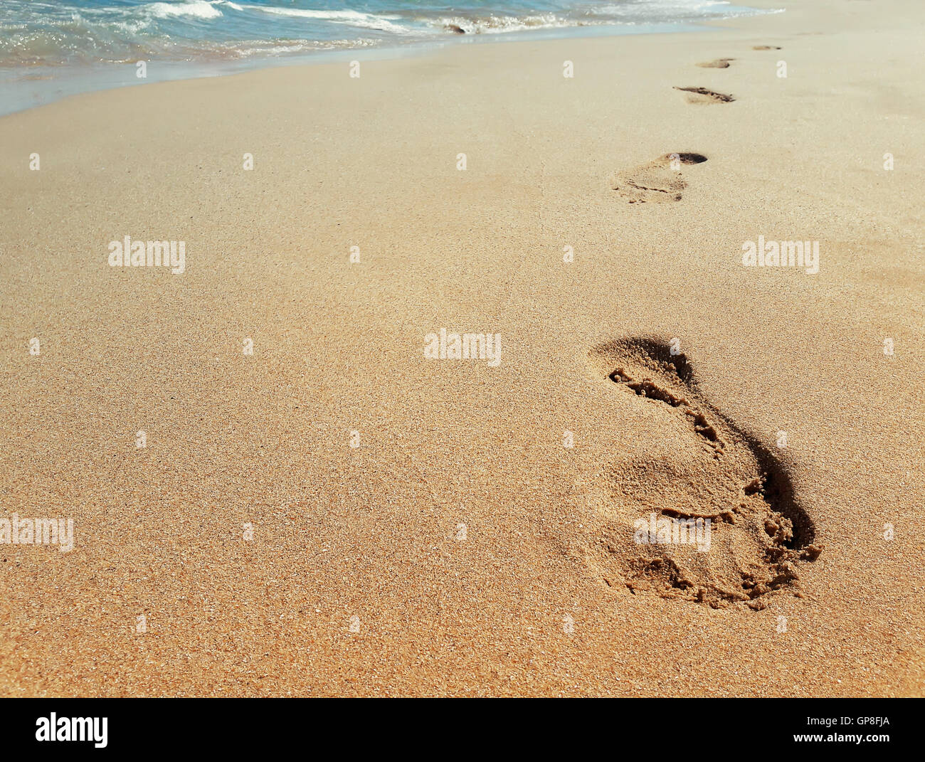 Libre d'empreintes de pas dans le sable à la plage près de l'eau. Concept Voyage Banque D'Images