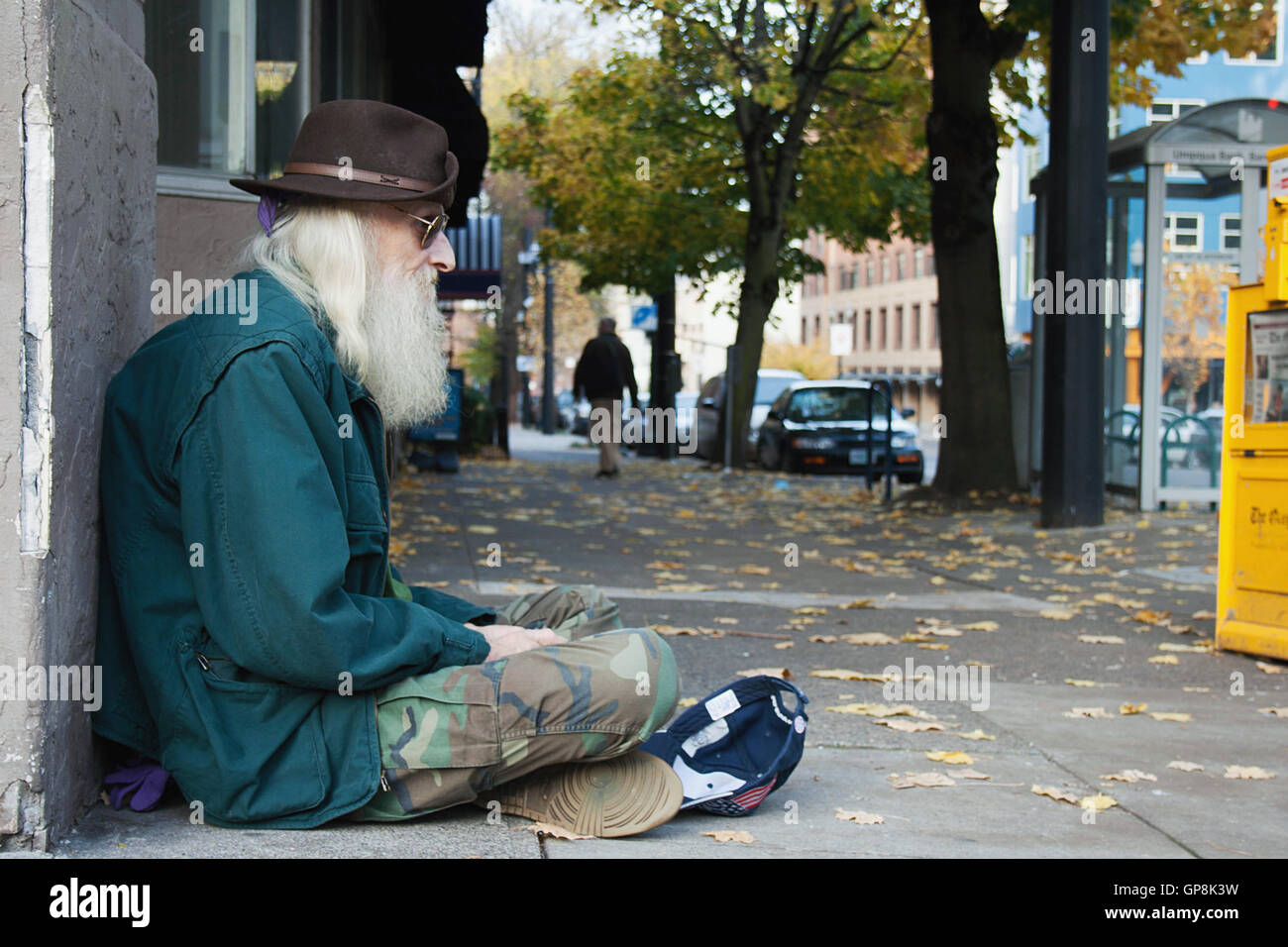 Personnes âgées, sans-abri assis sur un trottoir. Banque D'Images