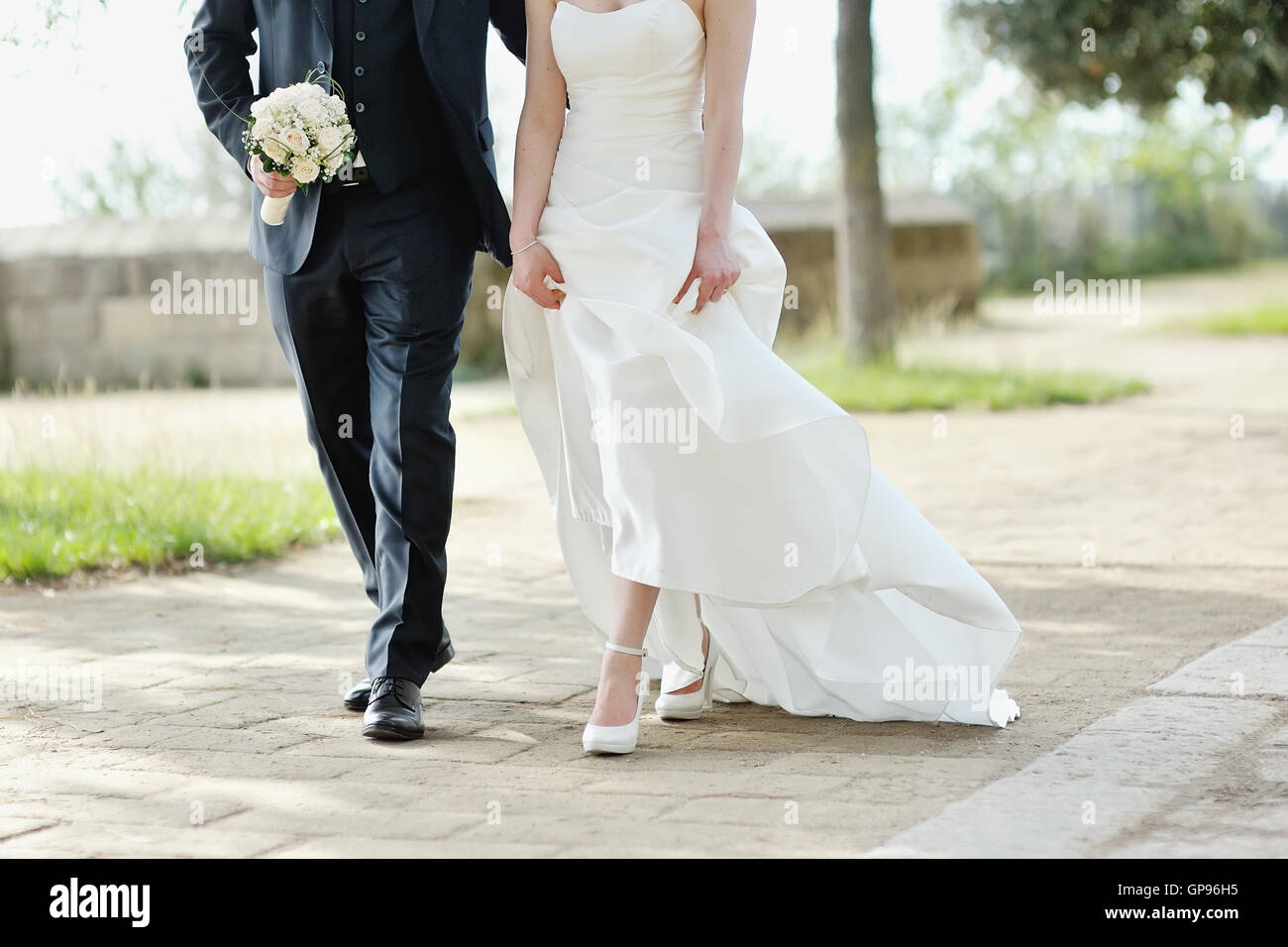 Mariée et le marié à marcher ensemble dans un parc à jour de mariage Banque D'Images
