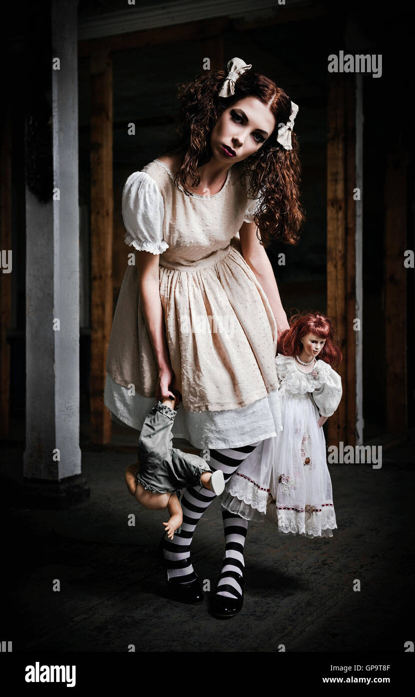L'étrange fille effrayante avec des poupées dans les mains Banque D'Images