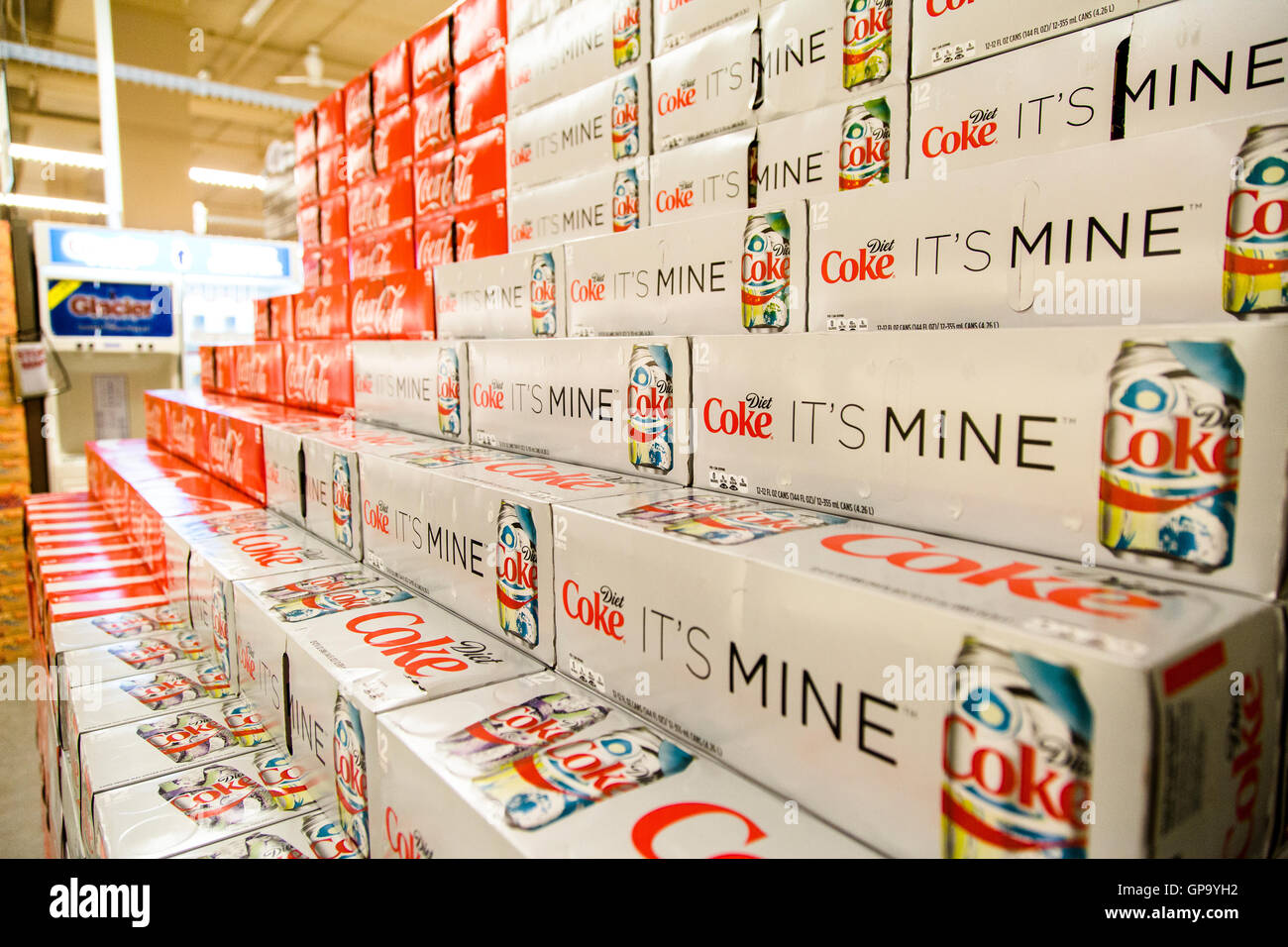 Les canettes de Coca-Cola cas empilés dans un affichage à l'épicerie. Banque D'Images