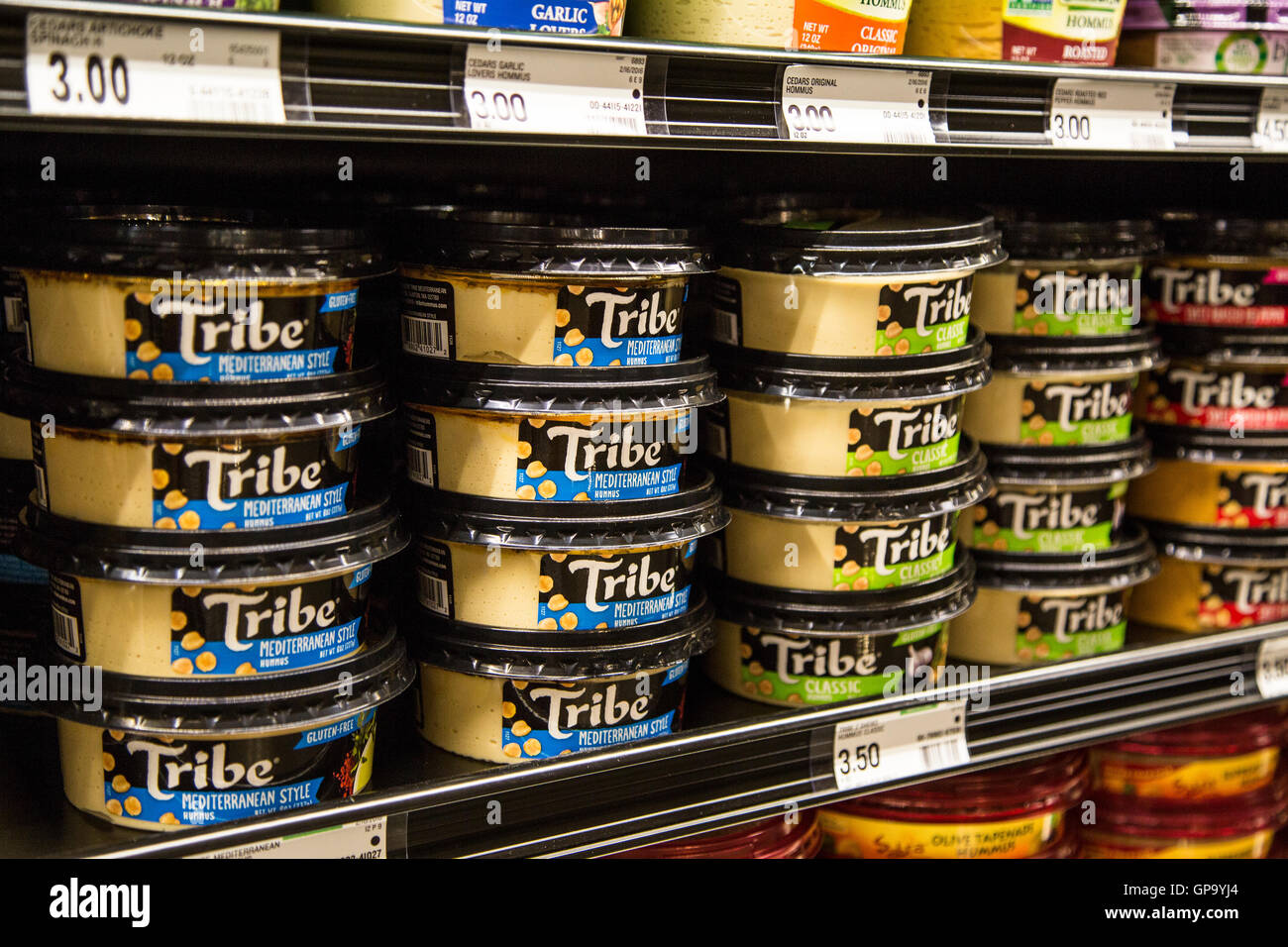 Les contenants de marque de la tribu de l'hoummos empilés sur une étagère dans une épicerie. Banque D'Images