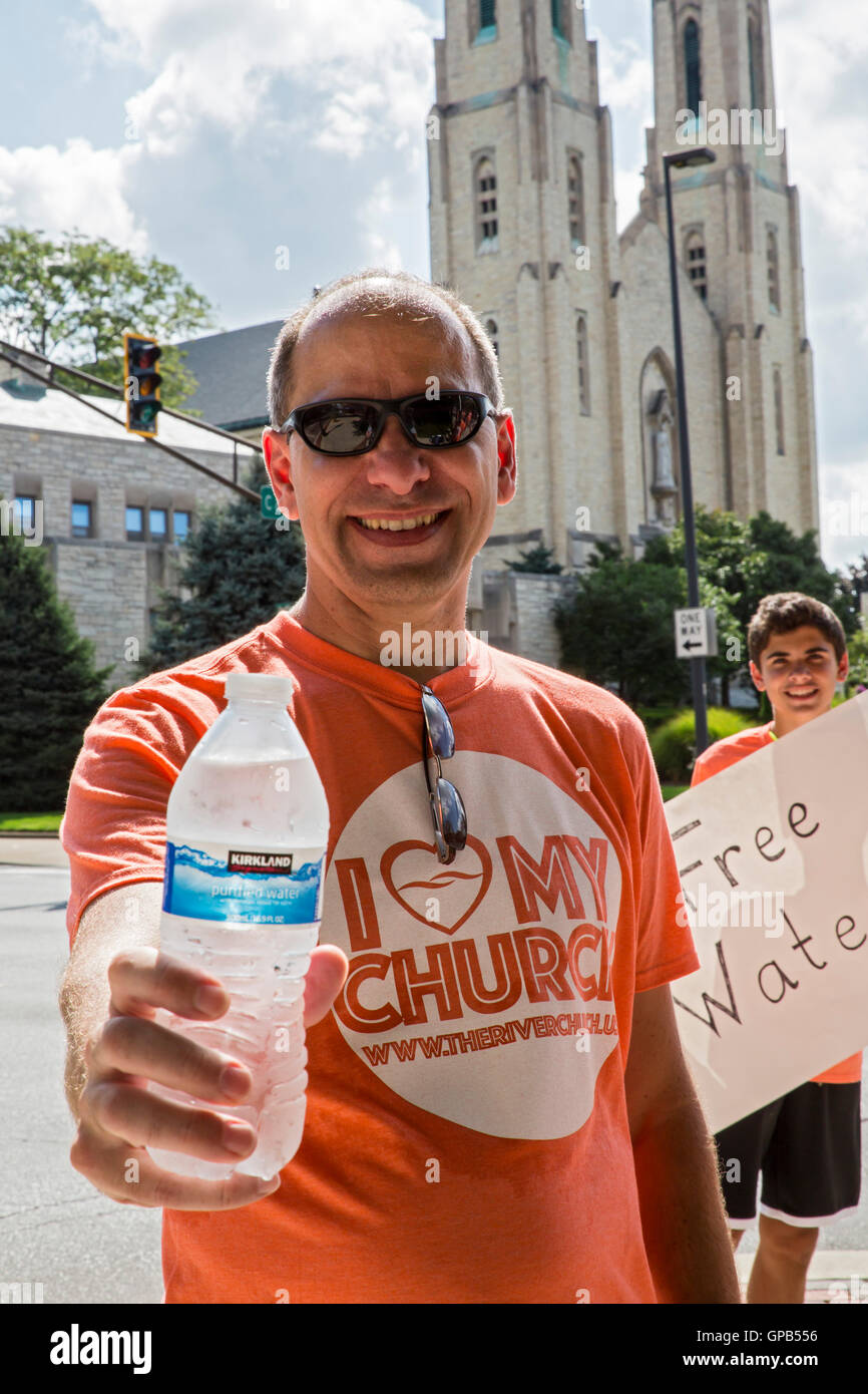 Fort Wayne, Indiana - Membres de l'Église chrétienne de la rivière distribuer gratuitement des bouteilles d'eau sur un coin de rue du centre-ville. Banque D'Images